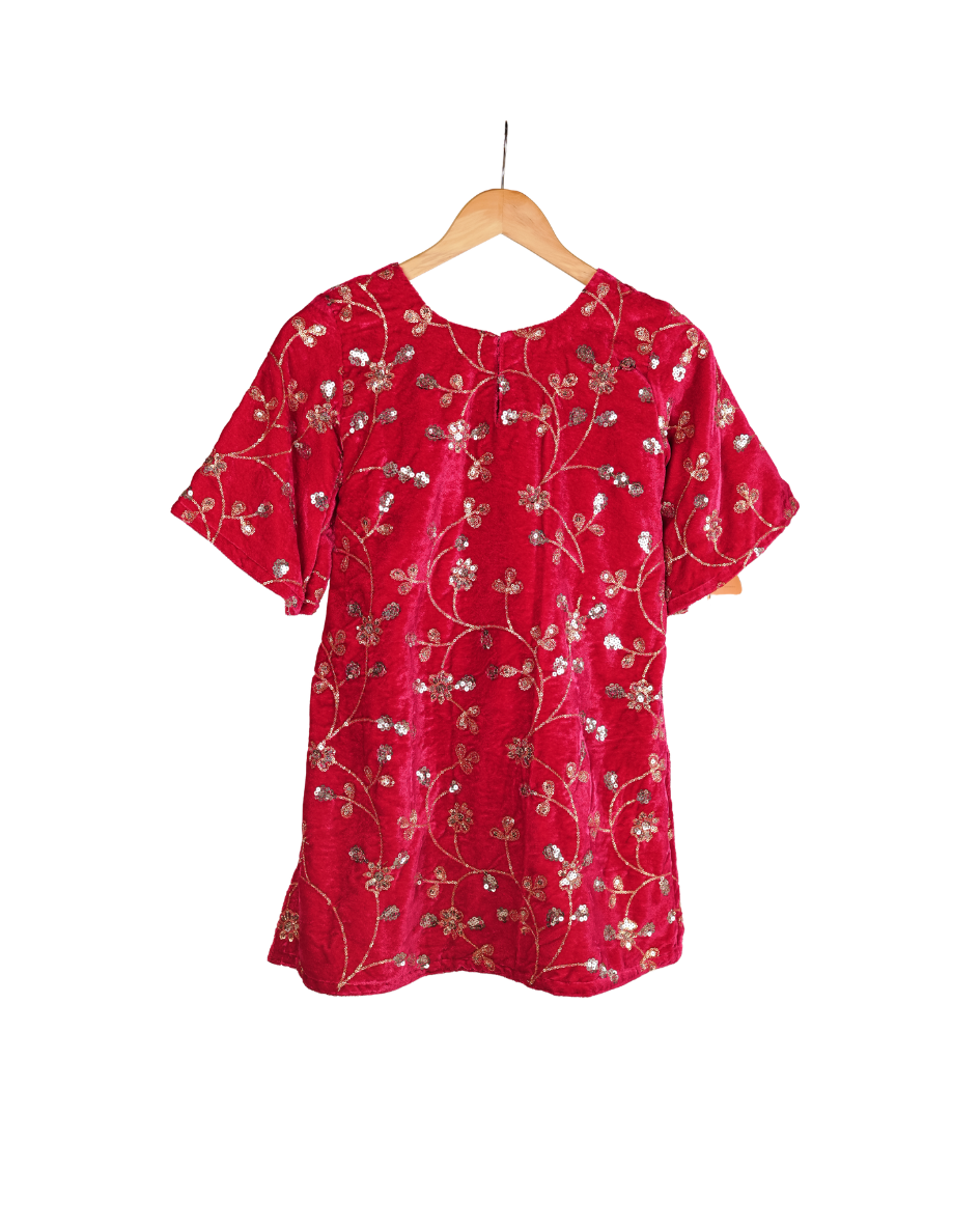 Red dress with floral pattern on a hanger against a white background
