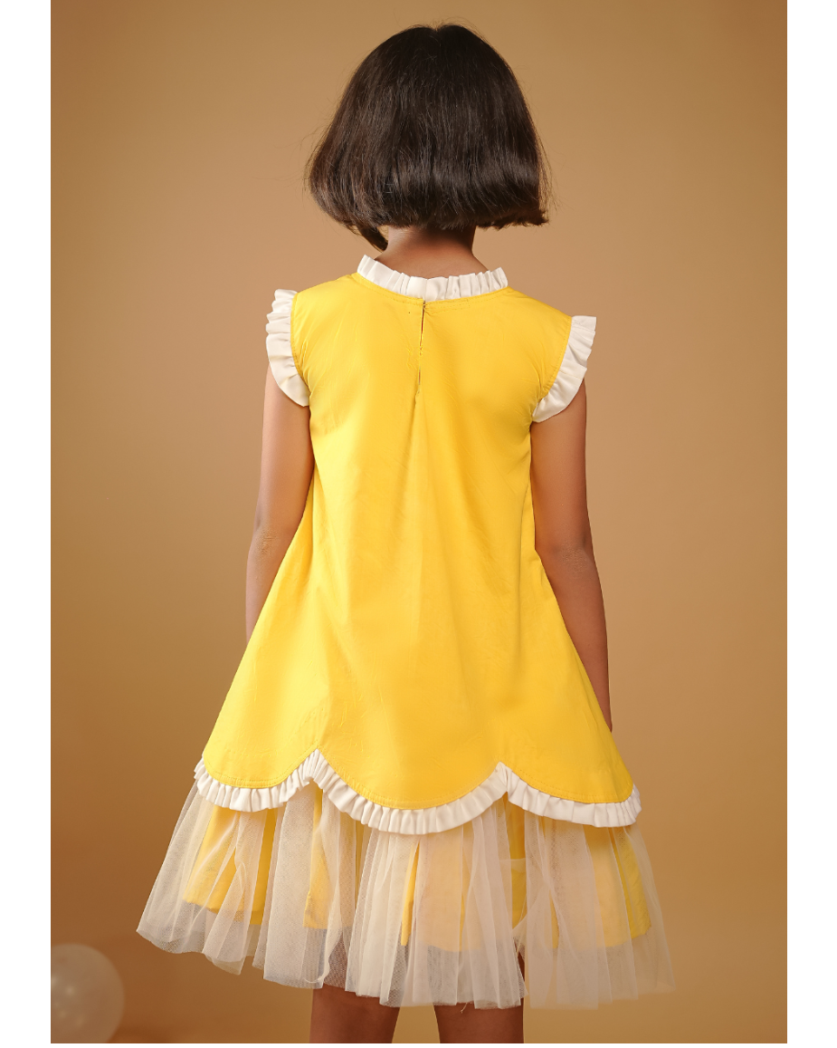 Child wearing a yellow dress with white ruffles on a beige background