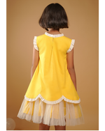 Child wearing a yellow dress with white ruffles on a beige background