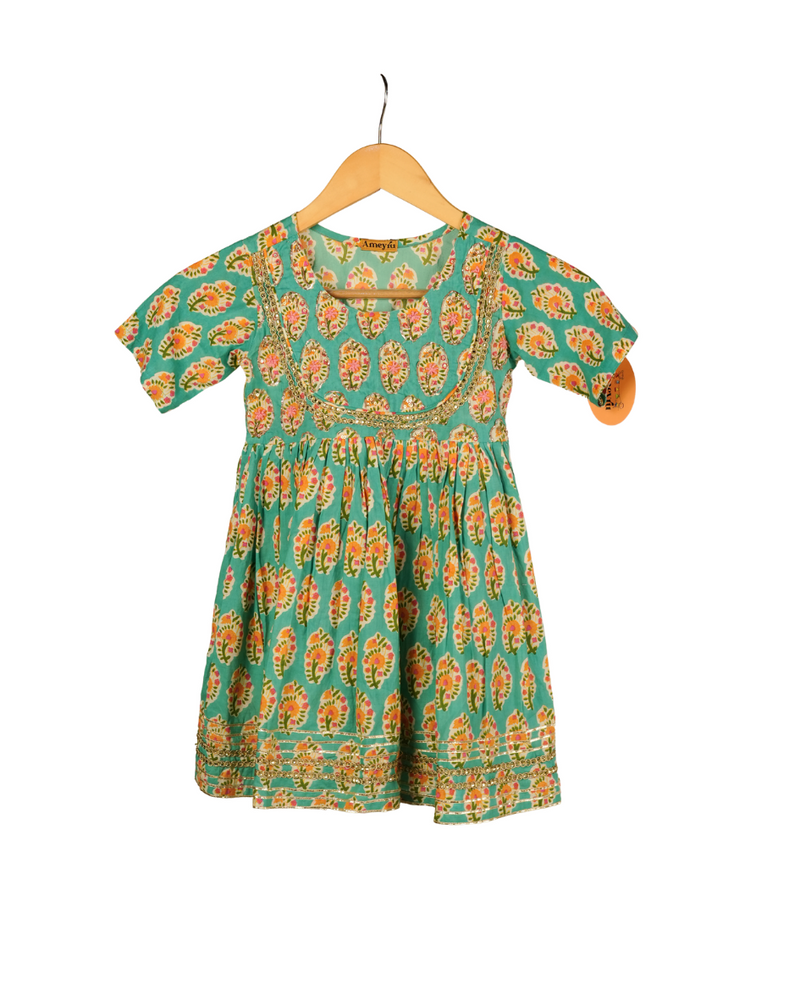 Green dress with orange floral pattern on a hanger against a white background