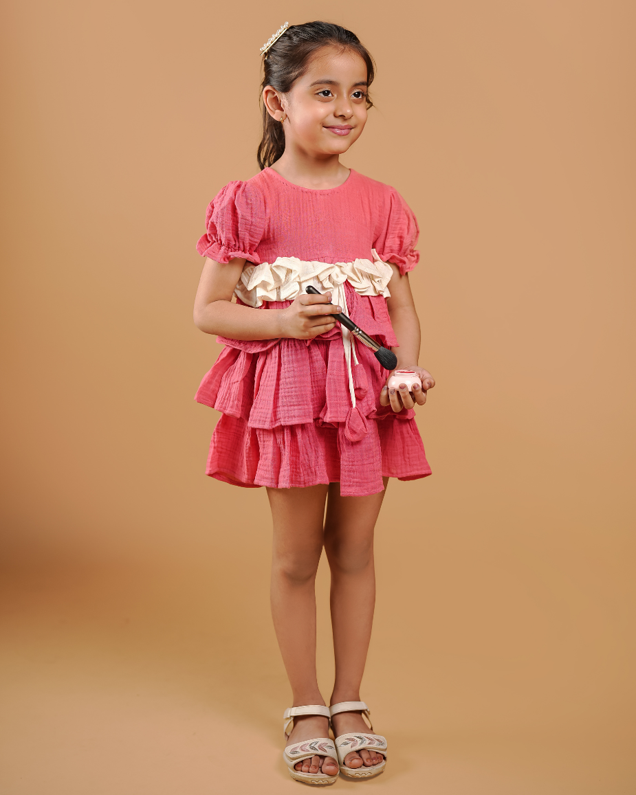 Young girl in a pink dress holding a white flower against a beige background