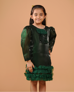 Young girl wearing a green dress with ruffled details against a beige background