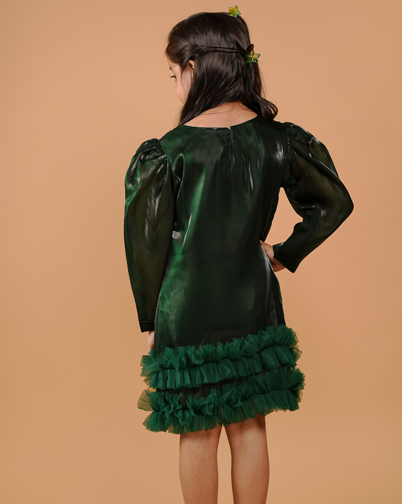 Green dress with ruffled skirt worn by a person on a beige background
