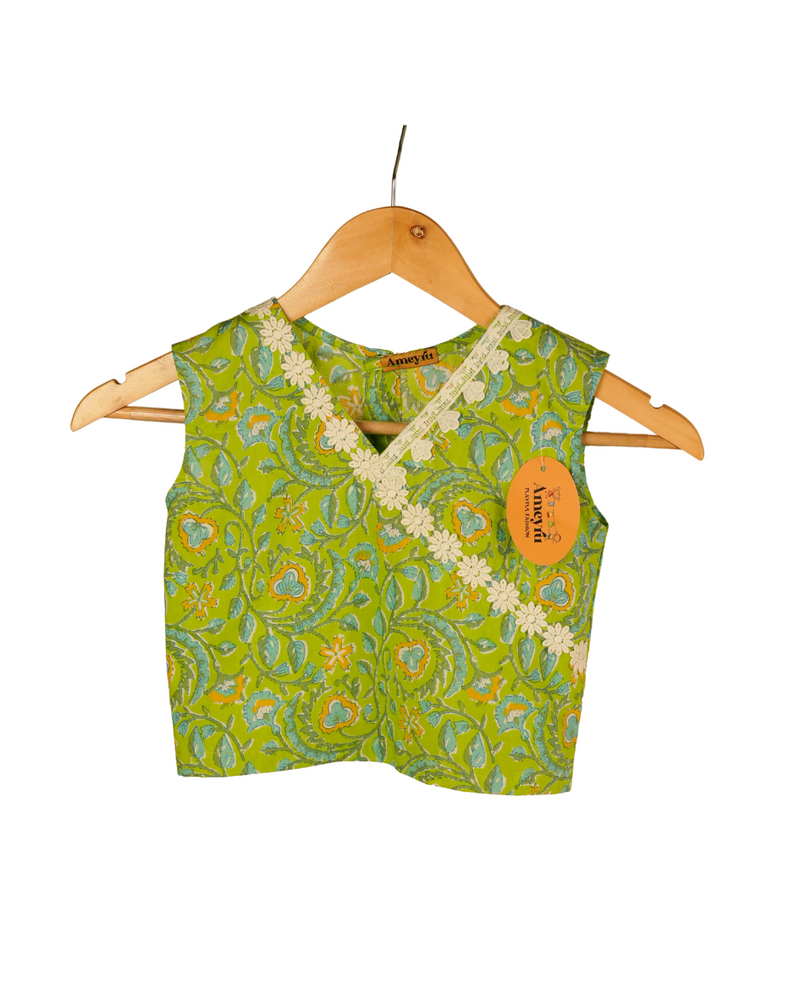 Green patterned top on a hanger with a visible brand tag.