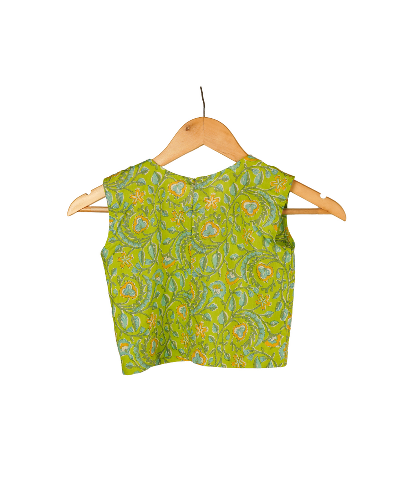 Green patterned top on a wooden hanger against a white background