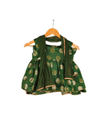 Green patterned dress on a wooden hanger against a white background