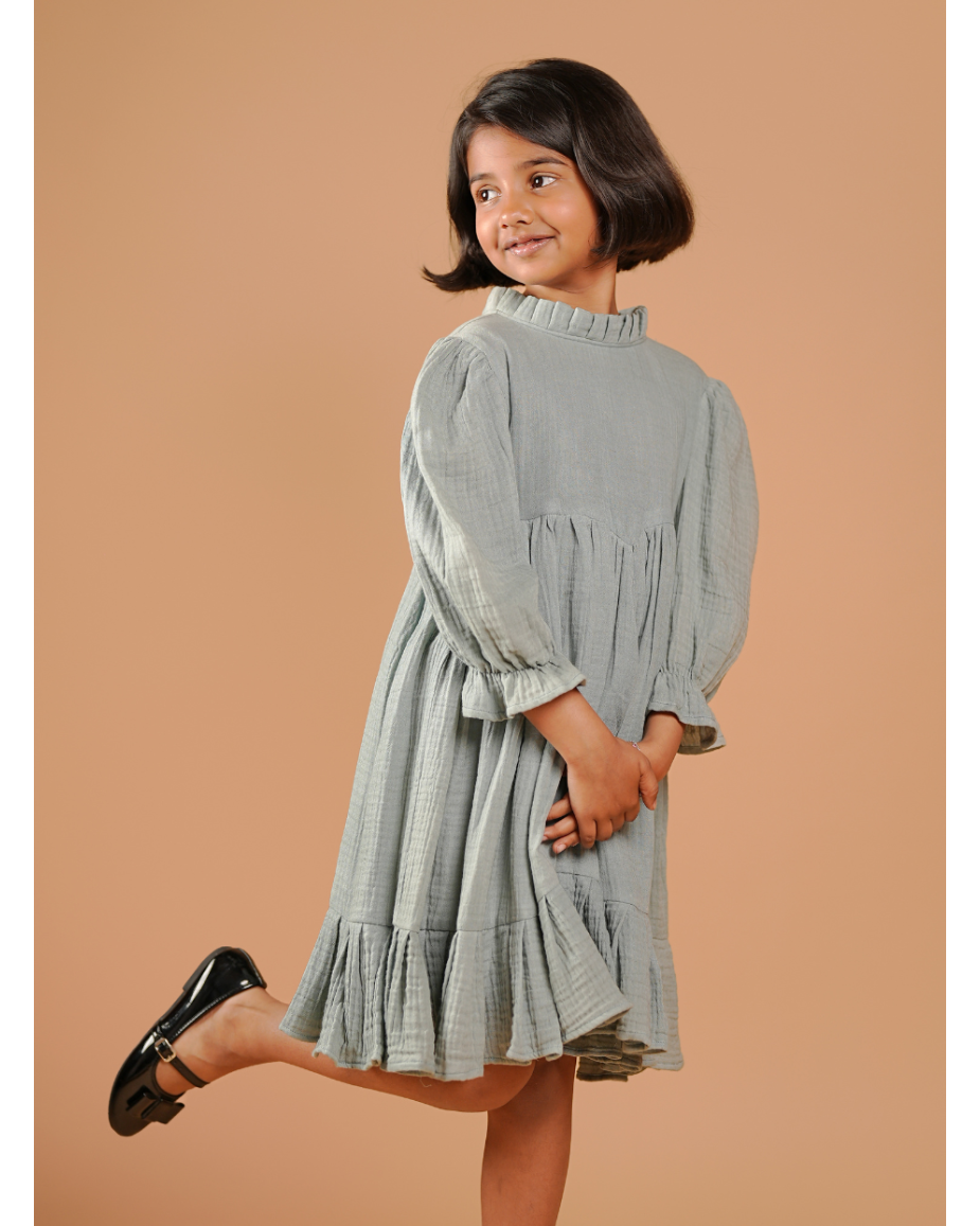 Young girl wearing a light blue dress against a beige background