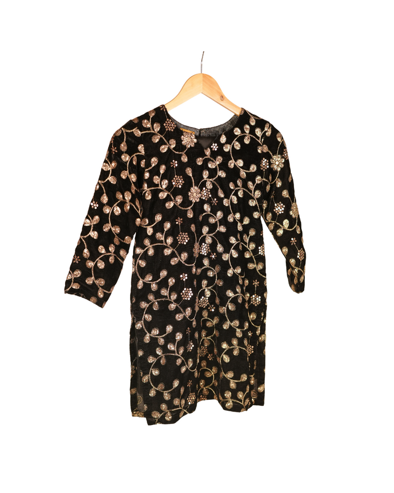 Black dress with gold floral pattern on a hanger against a white background