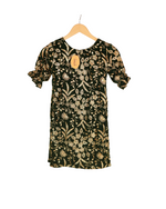 Black dress with gold floral pattern on a hanger against a white background