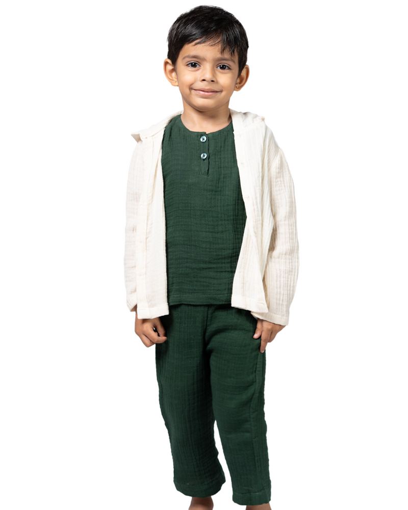 Child wearing a green outfit with a white cardigan on a white background