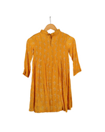 Yellow dress on a hanger against a white background