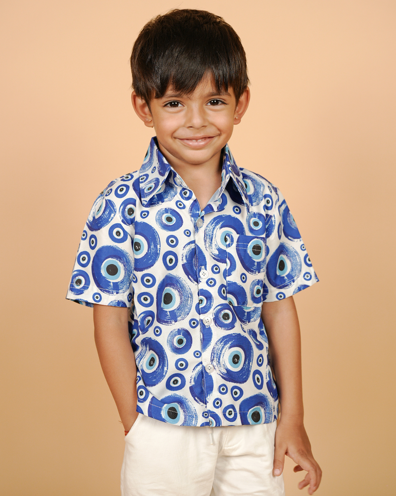 Child wearing a blue patterned shirt on a beige background