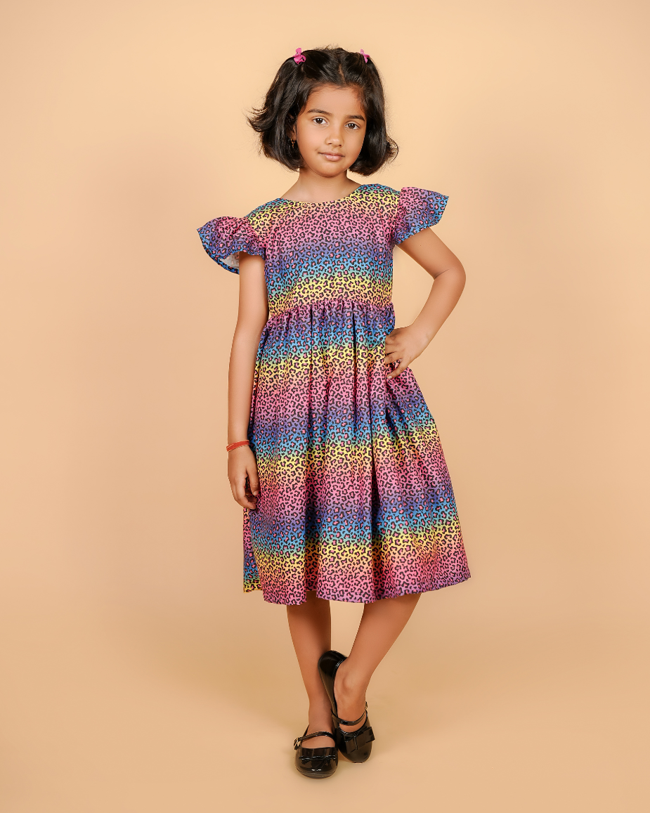 Young girl wearing a colorful dress against a beige background