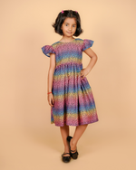 Young girl wearing a colorful dress against a beige background