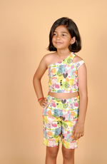 Young girl wearing a colorful outfit with a pattern on a beige background