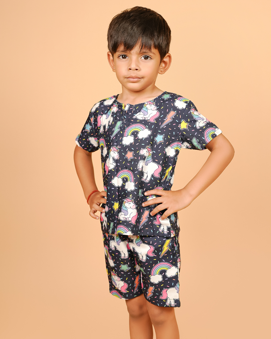 Child wearing a cord set with unicorn and rainbow pattern on a beige background