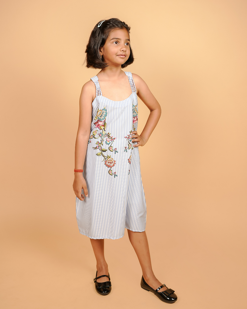 Young girl wearing a white dress with floral embroidery on a beige background