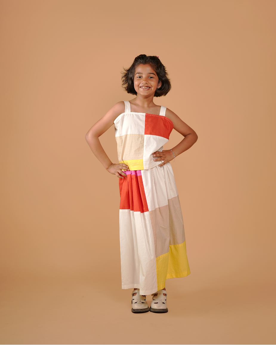 Young girl wearing a colorful dress against a beige background
