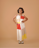 Young girl wearing a colorful dress against a beige background