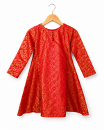 Red patterned dress on a wooden hanger against a white background