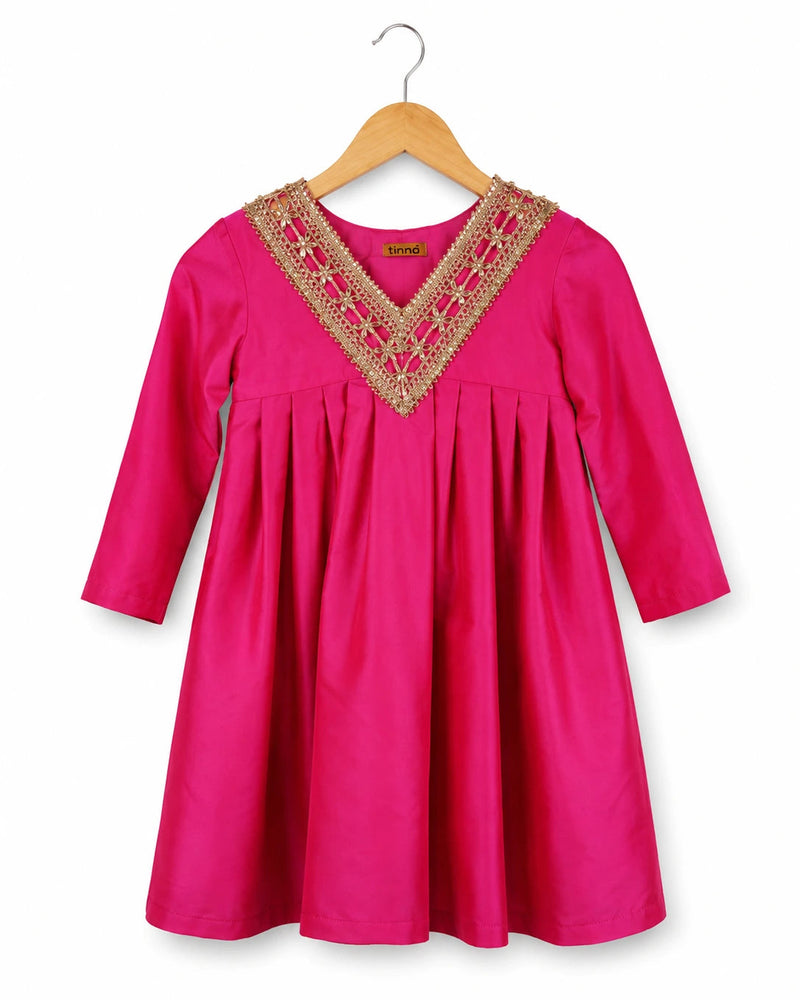 Pink dress with gold embroidery on a hanger against a white background