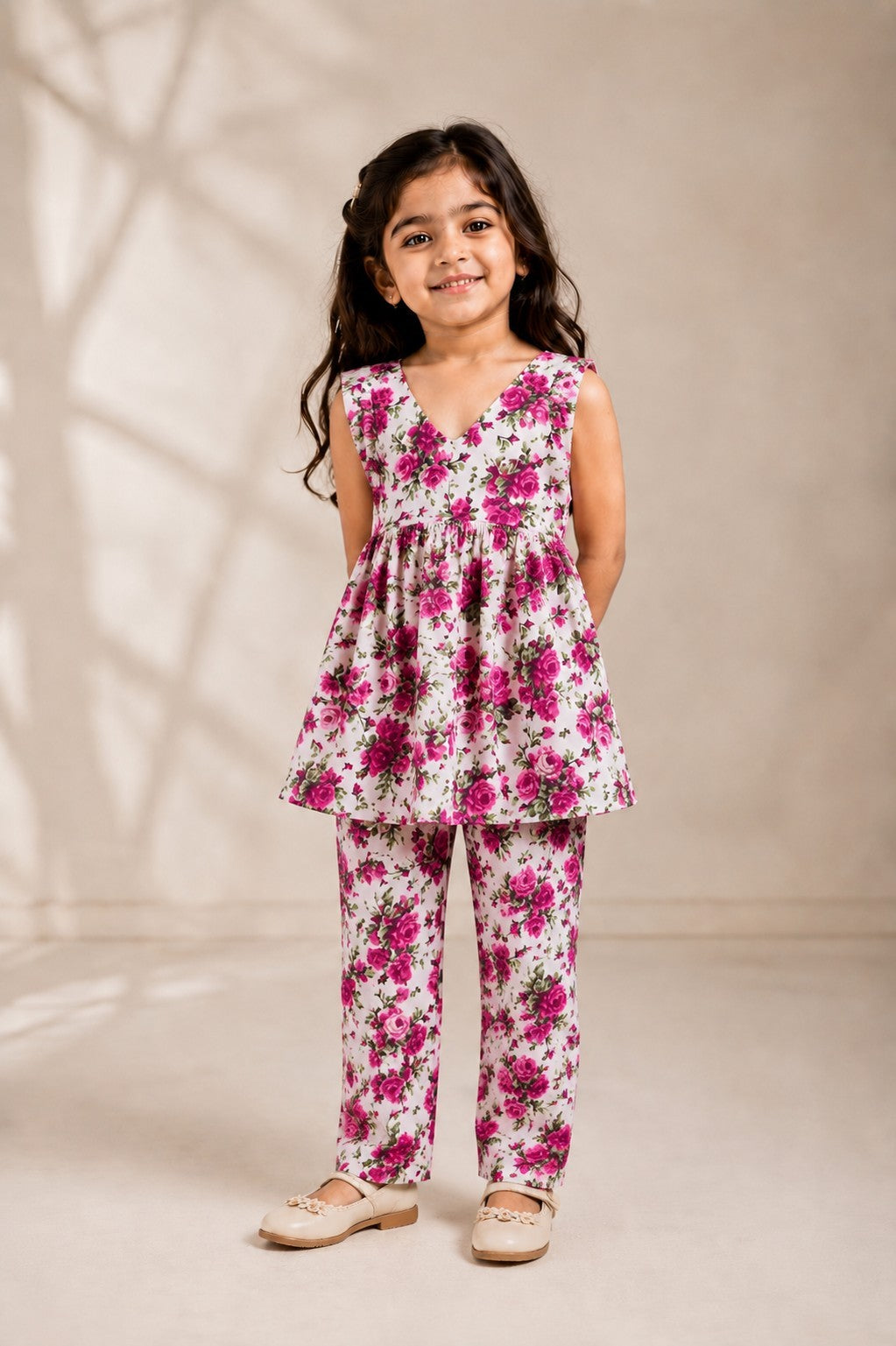 Young girl wearing an Ameyru Kids Wear floral co-ord set with a sleeveless peplum top and matching trousers.