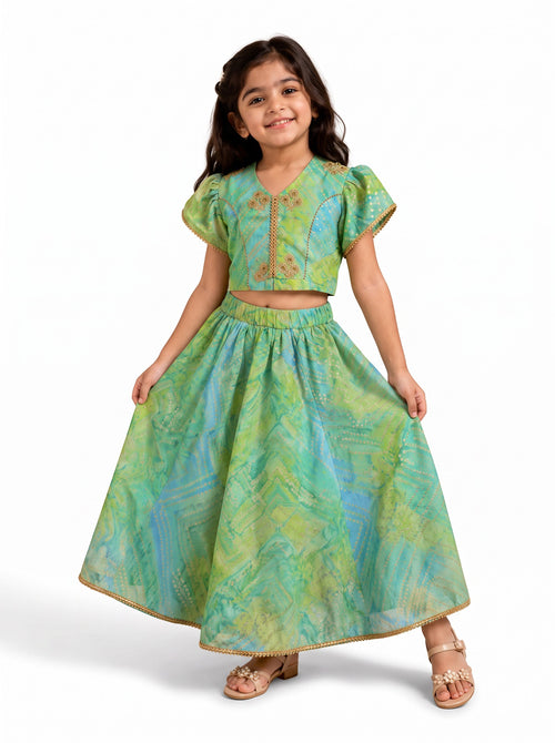 Ameyru Kids Wear green and blue printed lehenga choli with puff sleeves and gold embroidery on a young girl