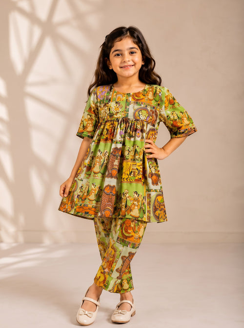 Ameyru Kids Wear girl wearing a green ethnic co-ord set with vibrant folk art prints, gathered tunic, and matching pants.