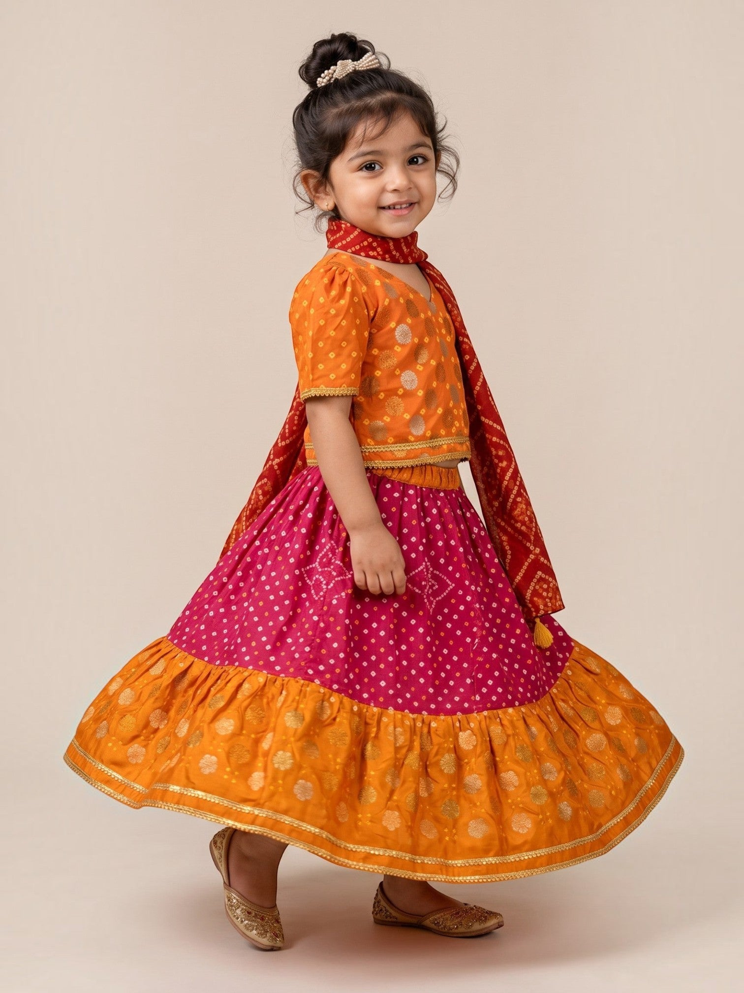 Ameyru Kids Wear orange and magenta lehenga choli with bandhani print, gold foil motifs, and flared skirt for girls.