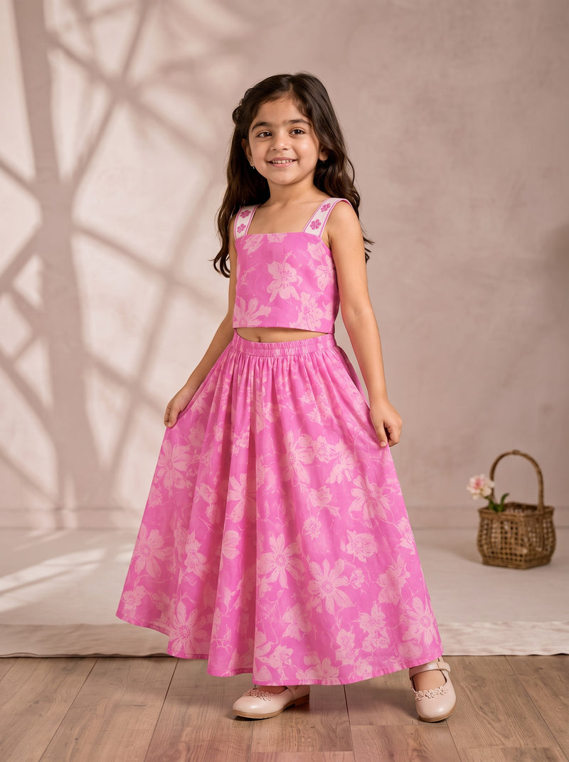 Ameyru Kids Wear pink floral crop top and floor-length skirt set worn by a smiling girl in a studio setting.