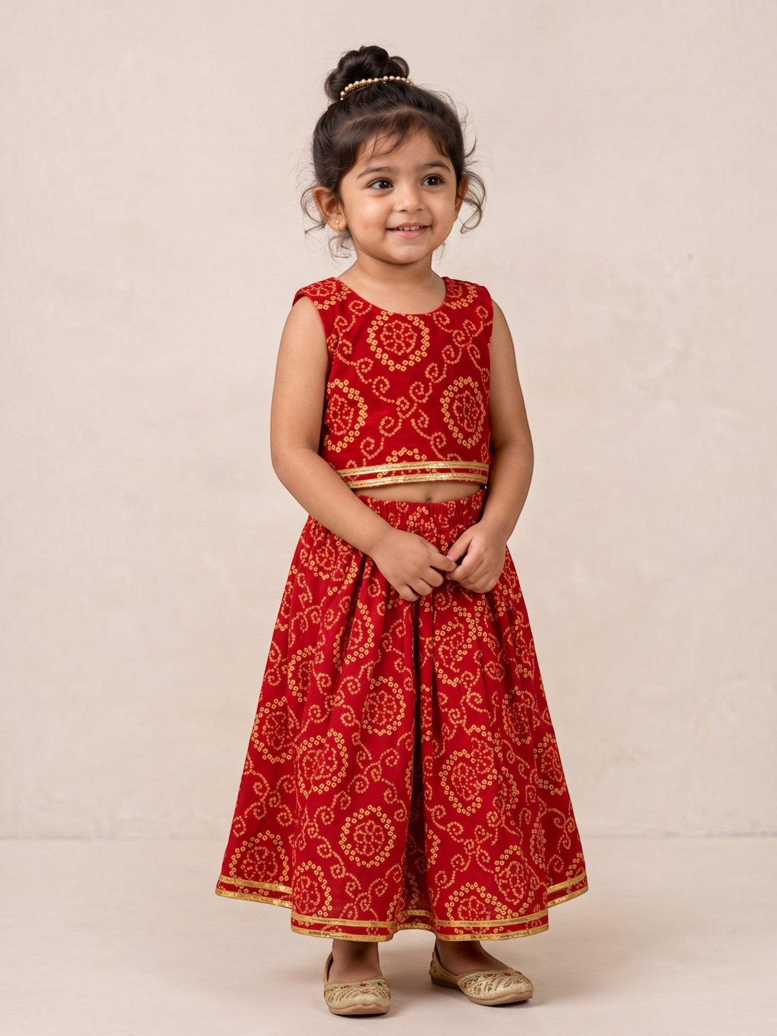 Ameyru Kids Wear red ethnic lehenga choli with gold bandhani patterns and trim on a young girl