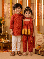 Ameyru Kids Wear traditional red ethnic outfits for a boy and girl with festive patterns in a decorated room