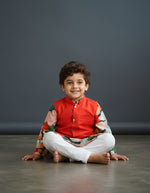 Baby Kids Cloths boy wearing a vibrant floral kurta with a red Nehru jacket and white bottoms for festive occasions.
