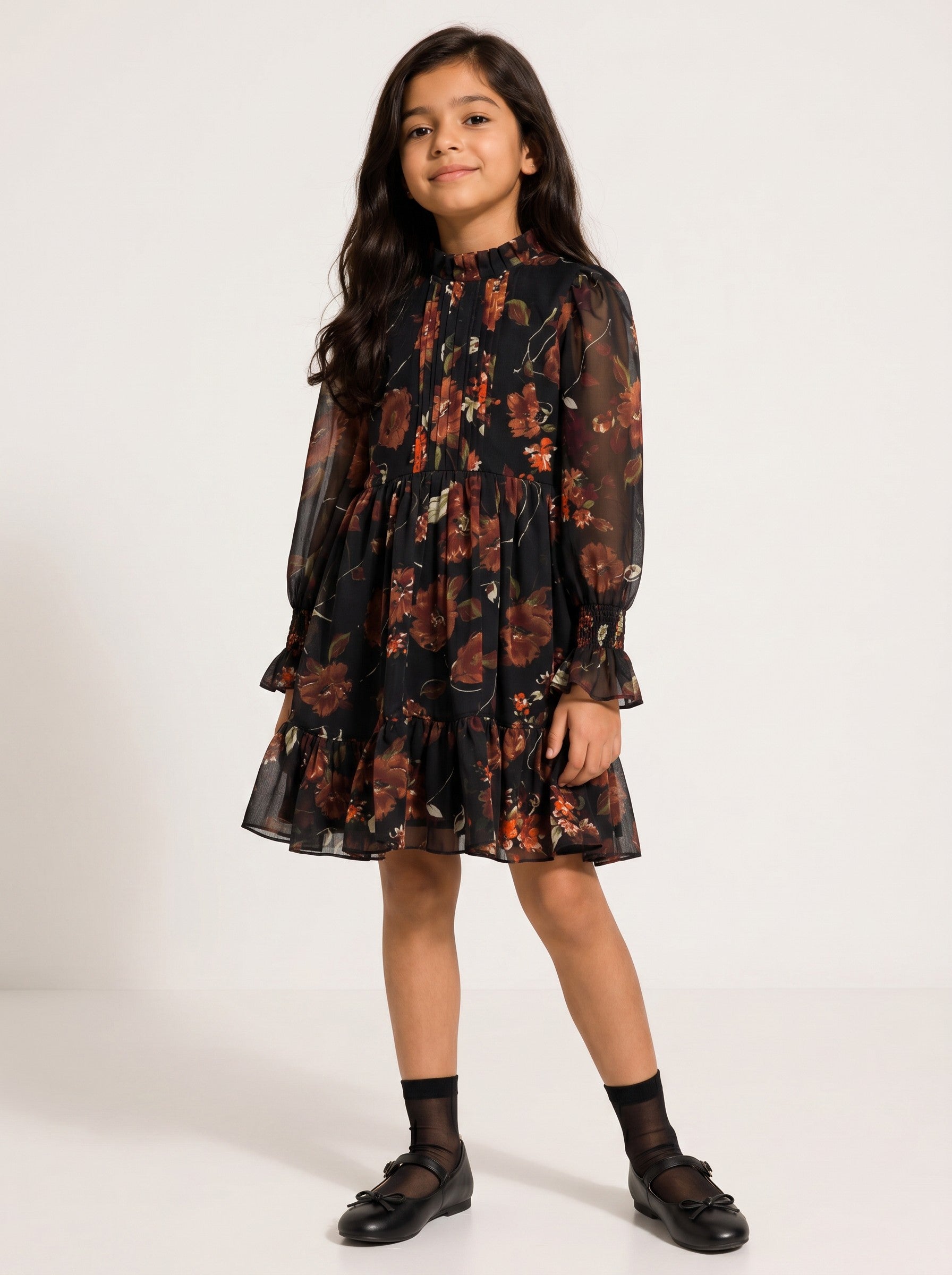 Baby Kids Cloths girl wearing a black floral print long sleeve mini dress with a ruffled hem and high neckline.