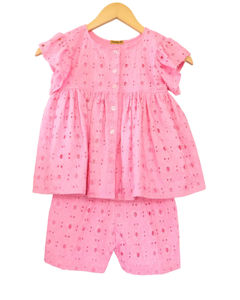 A pink cotton co-ord set for girls, with a ruffle sleeve top and matching shorts, displayed on a hanger.